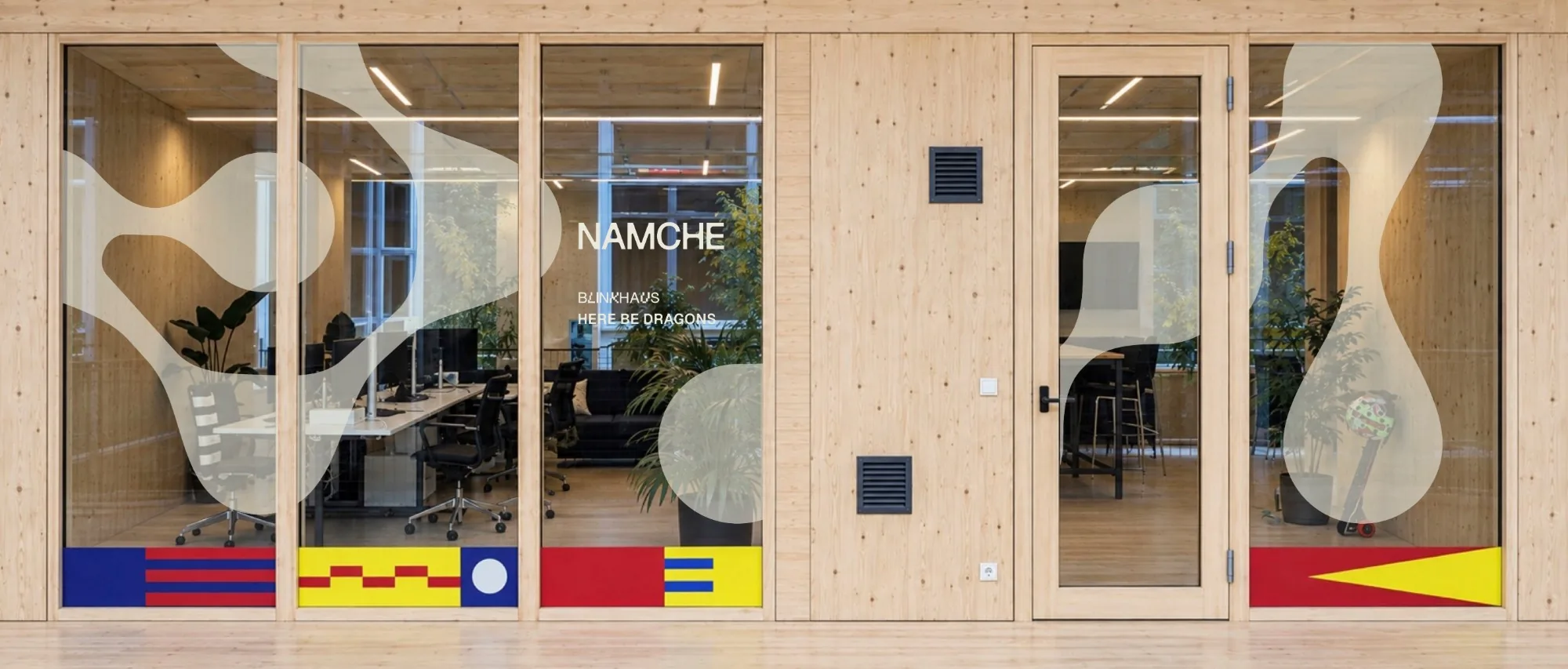 Mockup of the Namche office: a glass front with the NAMCHE lettering and metaball shapes, a wooden interior behind it.